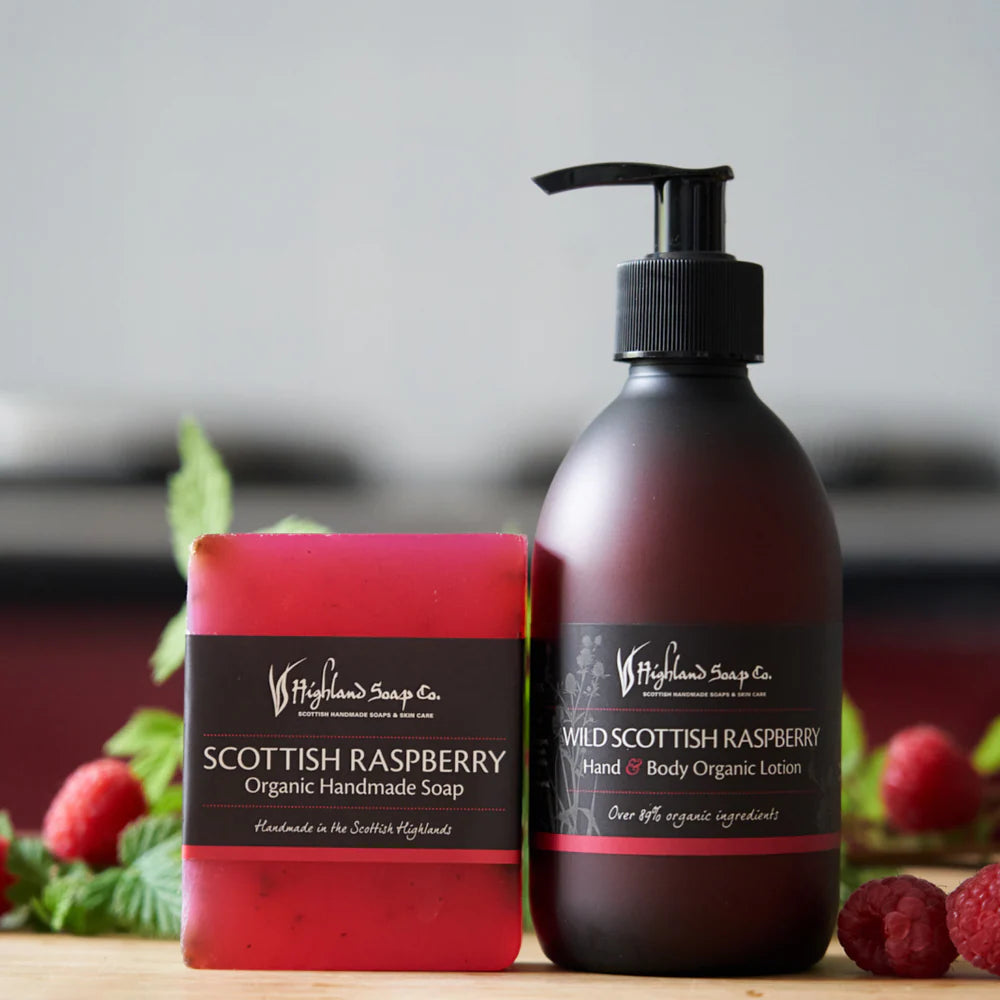 Scottish Raspberry soap and lotion set with raspberries and mint leaves on a wooden surface