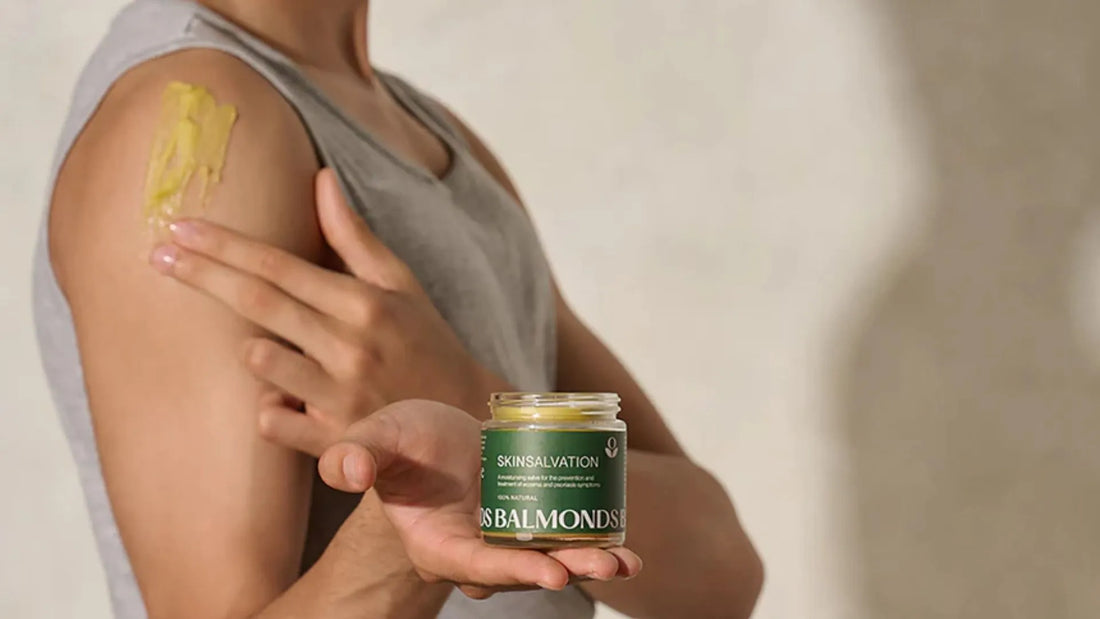 Man holding Balmonds Skin Salvation whilst putting on yellow swatch on arm