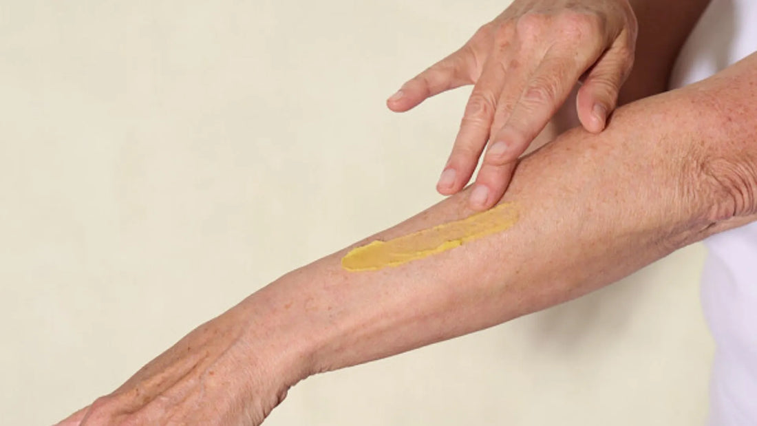 Older woman putting Balmonds Skin Salvation on arm