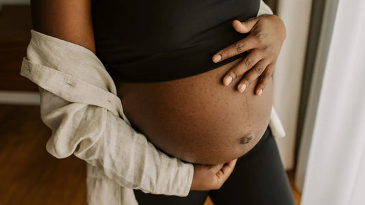 Woman holding pregnant belly avoiding certain skincare