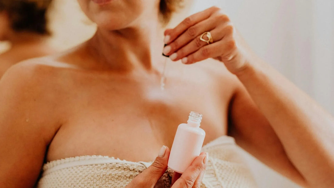 Woman in white robe using skincare