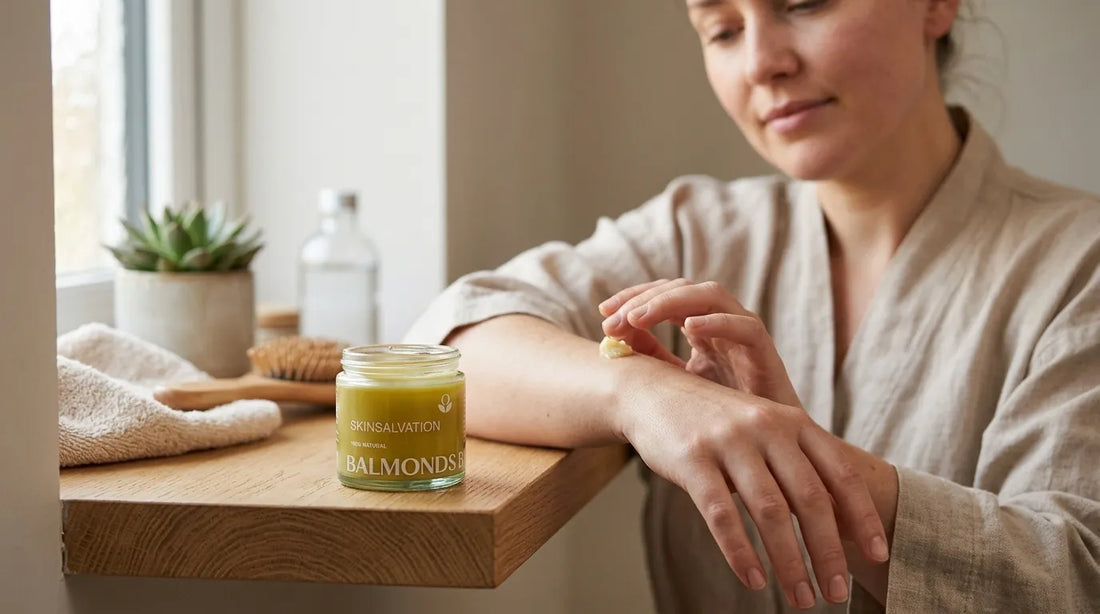 Woman in robe using Balmonds Skin Salvation while leaning on wooden shelf