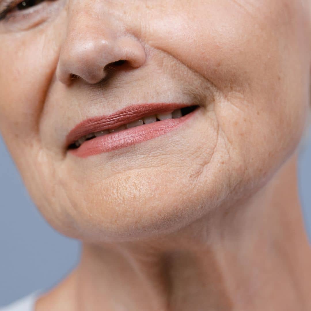 Older woman enjoying results of using anti ageing product