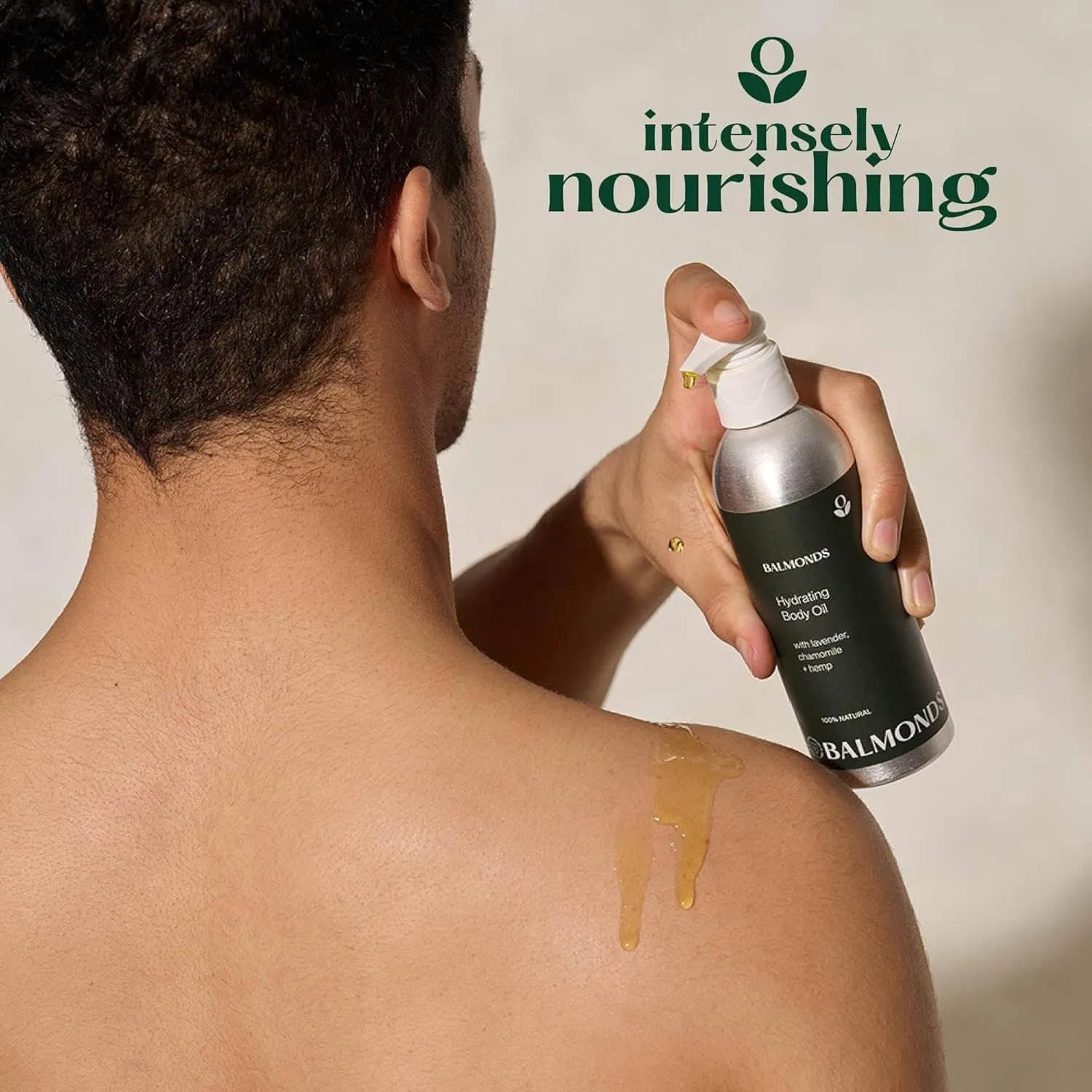 Person applying Balmonds Hydrating Body Oil to their shoulder with 'intensely nourishing' text above
