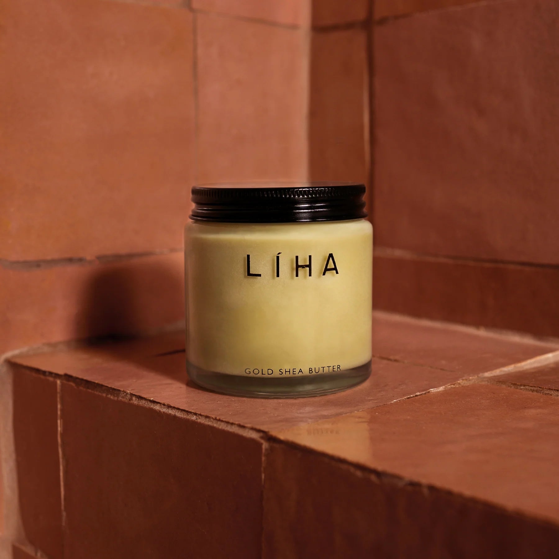 Jar of LIHA Gold Shea Butter on a wooden surface