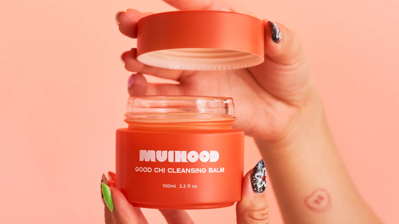 Woman opening up Muihood product on pink background