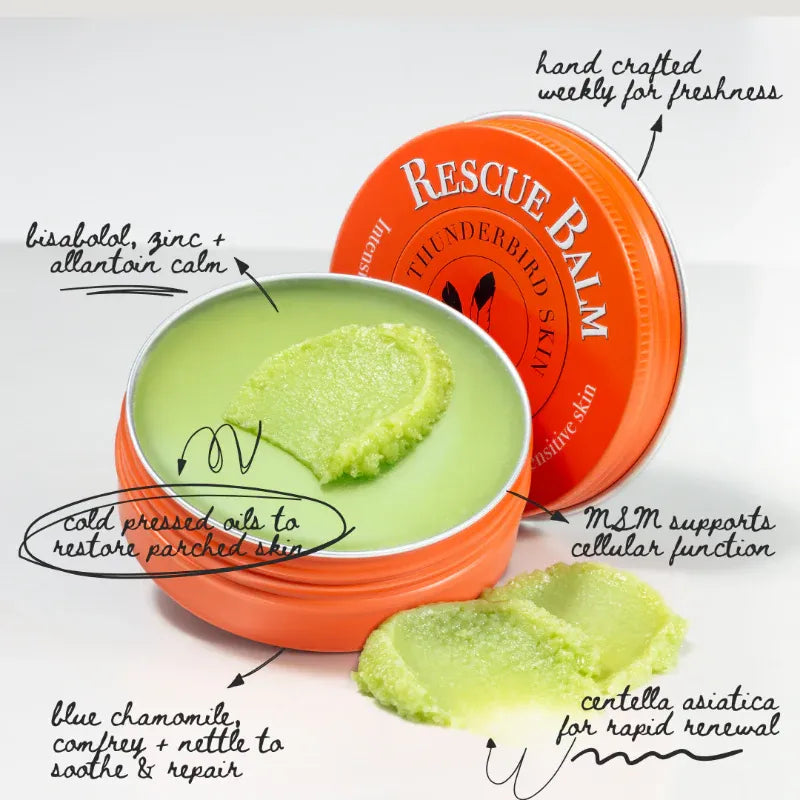 Orange tin of 'Rescue Balm' with green balm inside, labeled with benefits on a white background.
