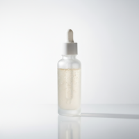 A frosted glass dropper bottle filled with a translucent pale yellow liquid, standing on a reflective white surface against a clean white background.